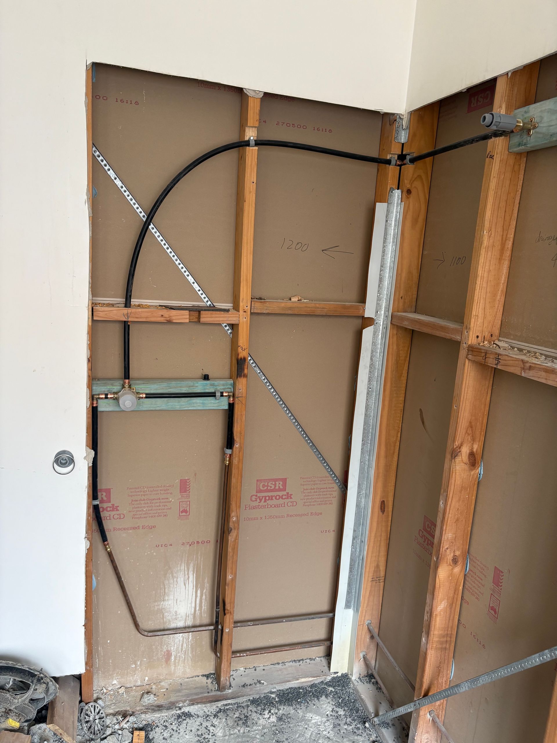 Exposed wall framing with insulation removed, visible braces, and electrical box in a room under renovation