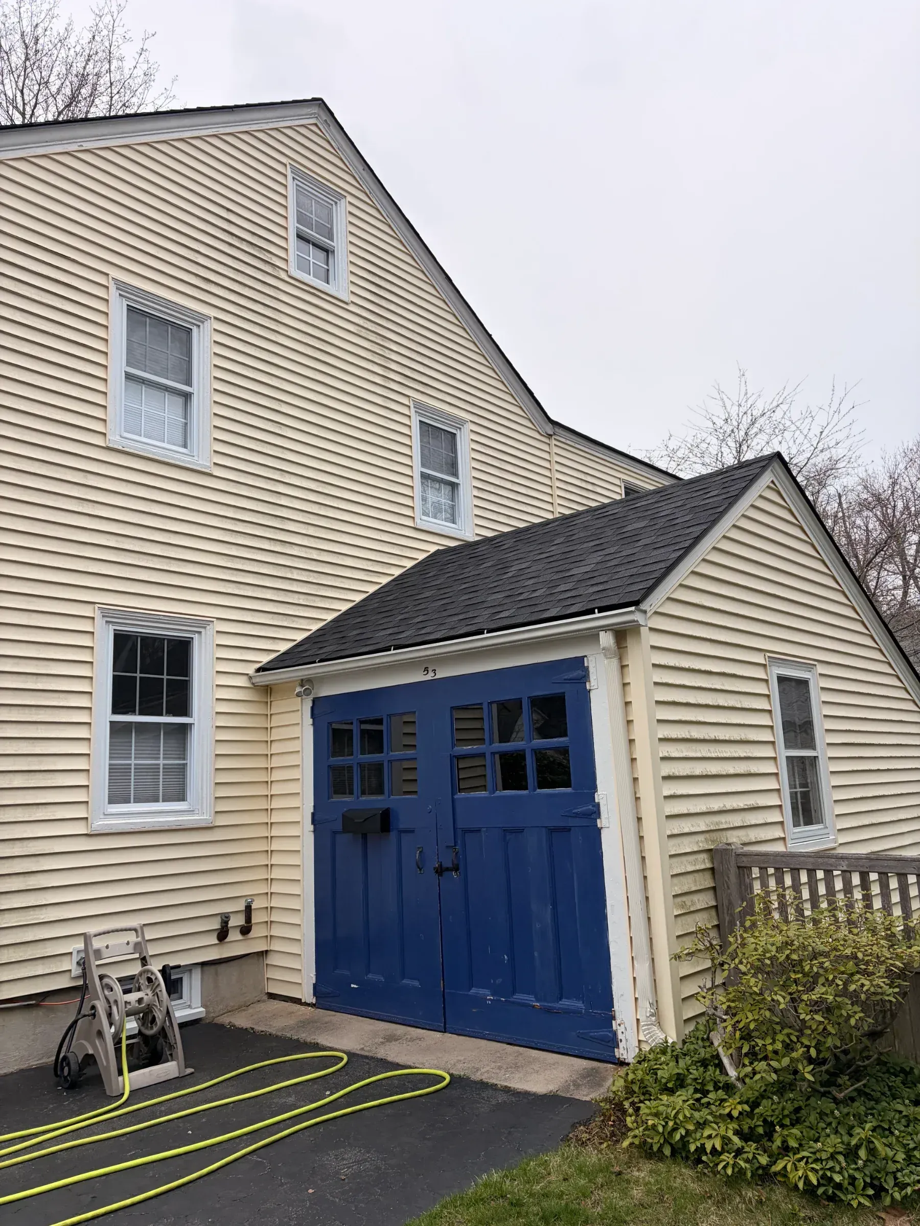 Beige house exterior with blue double doors and white-trimmed windows