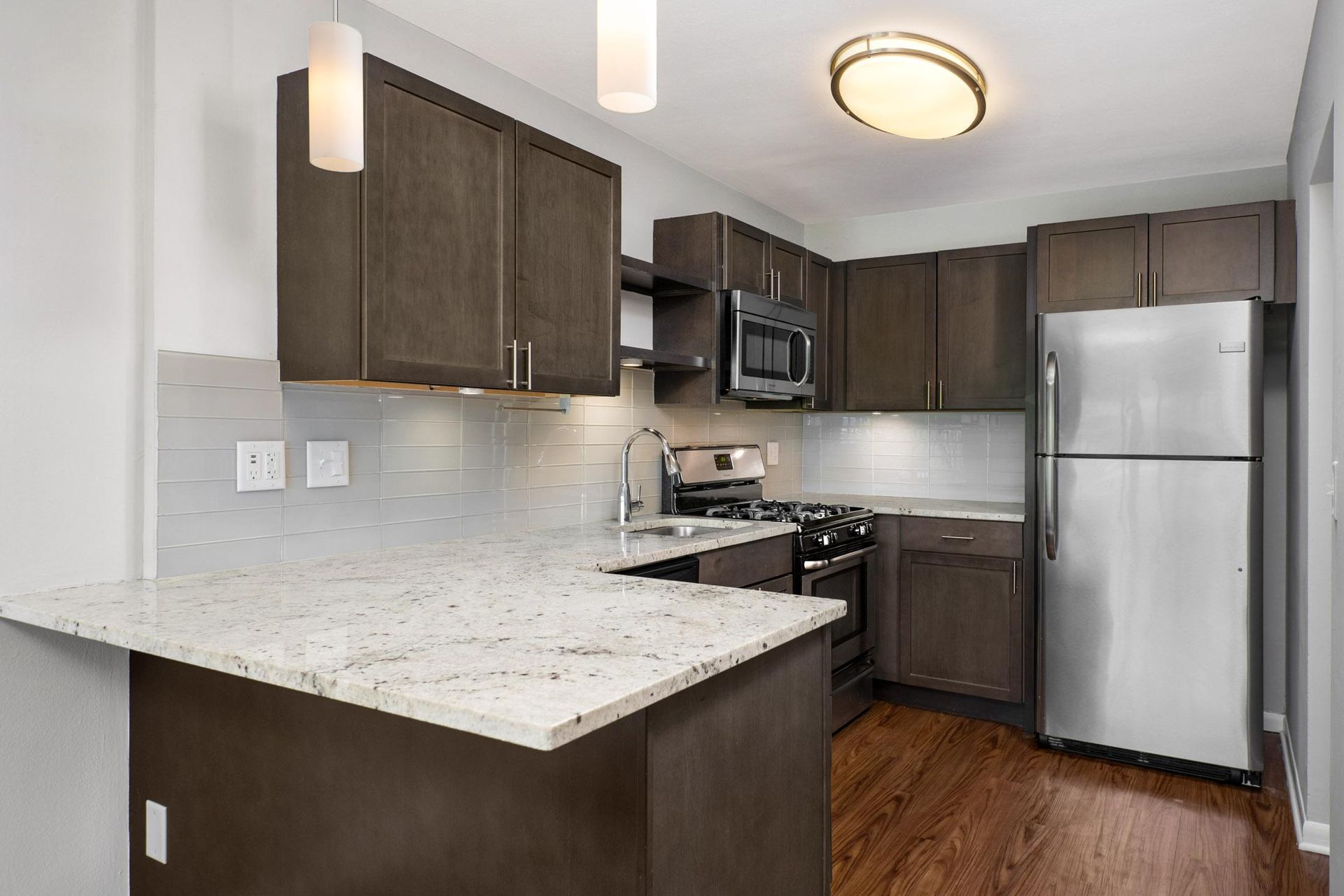 a kitchen with stainless steel appliances and a marble counter top