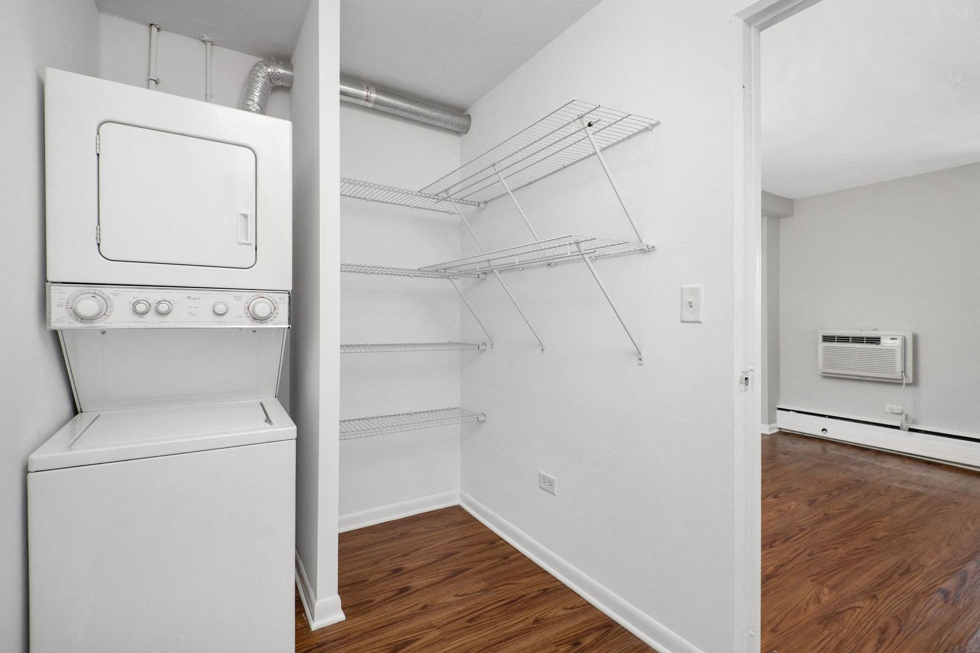 a laundry room with a washer and dryer and a closet with shelves