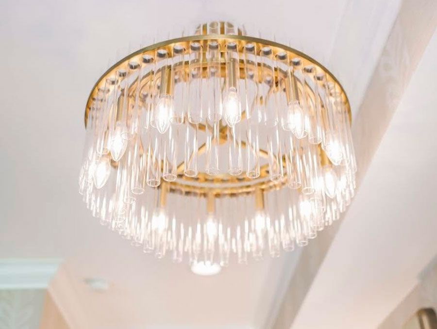 Gold and crystal chandelier hanging from a white ceiling