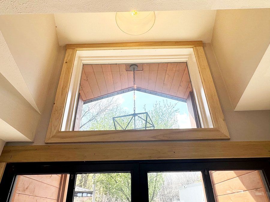 Open window showing a porch roof and sky, with a black window frame below