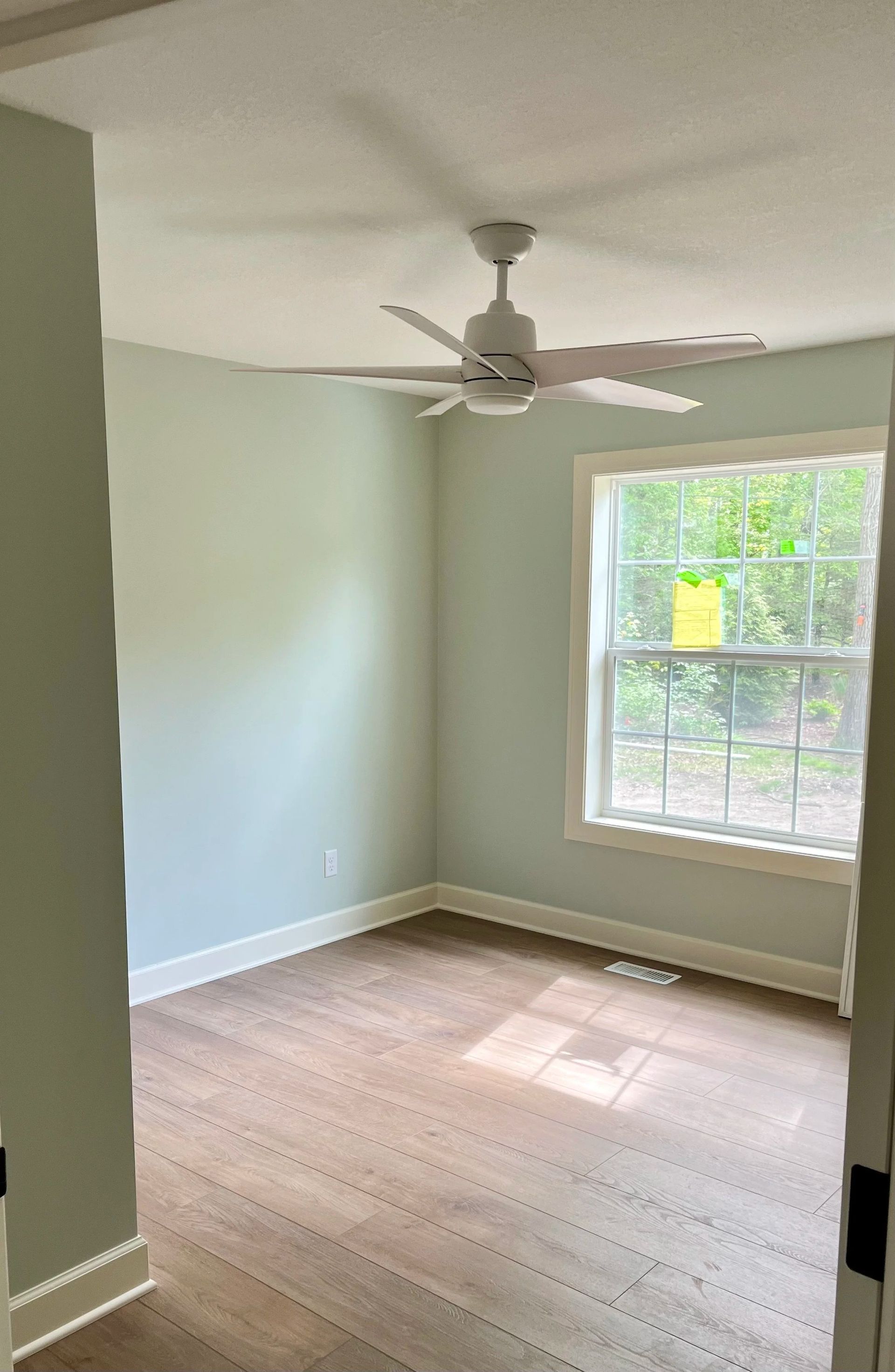 Unfinished room with exposed wooden framing, insulation boards, and a bright window at the far end.