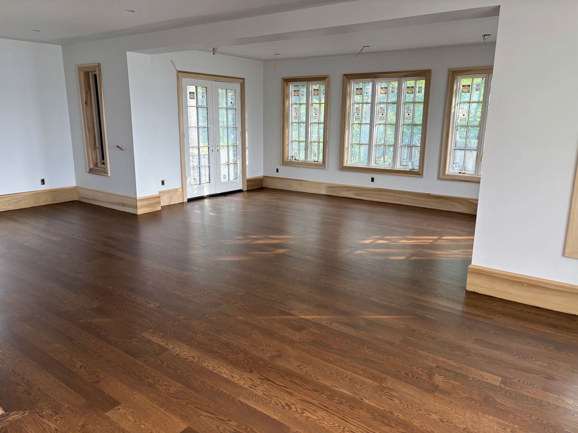 Stacked white doors and trim leaning in a room under renovation