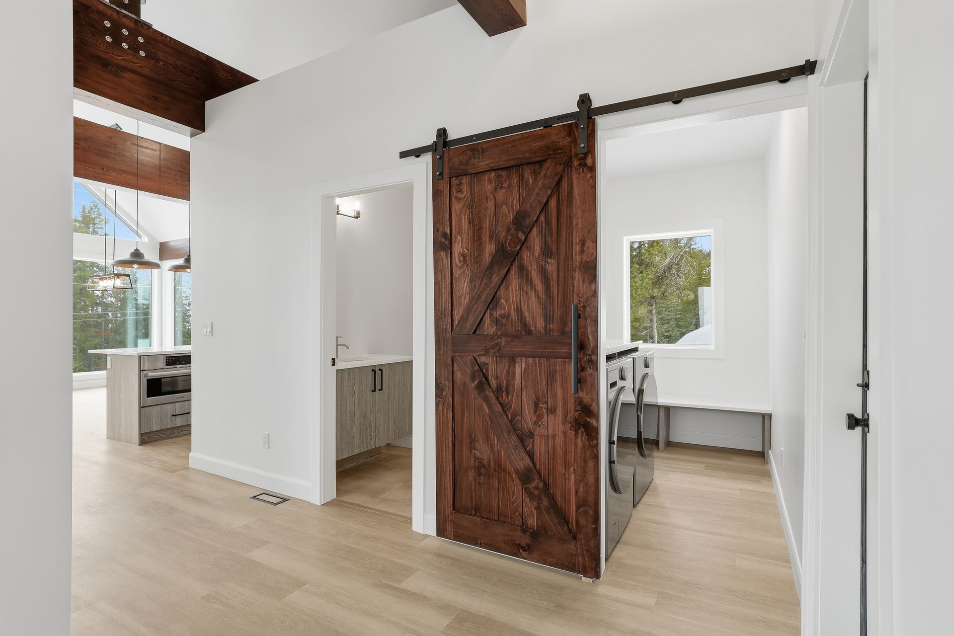 Bright modern room with a rustic sliding barn door and light wood floors