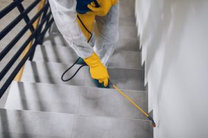 Person in yellow gloves measuring stairs with a tape measure