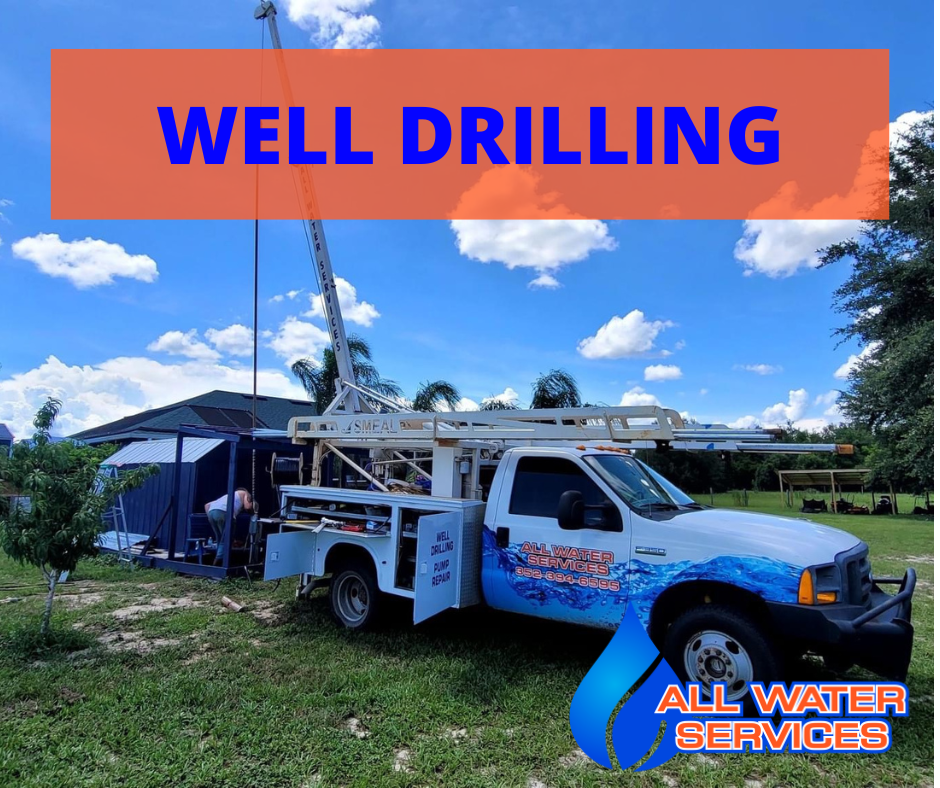 A well drilling truck is parked in a grassy field