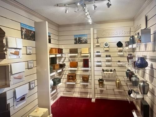 Shelved kitchenware displays in a bright retail showroom with red carpet and track lighting