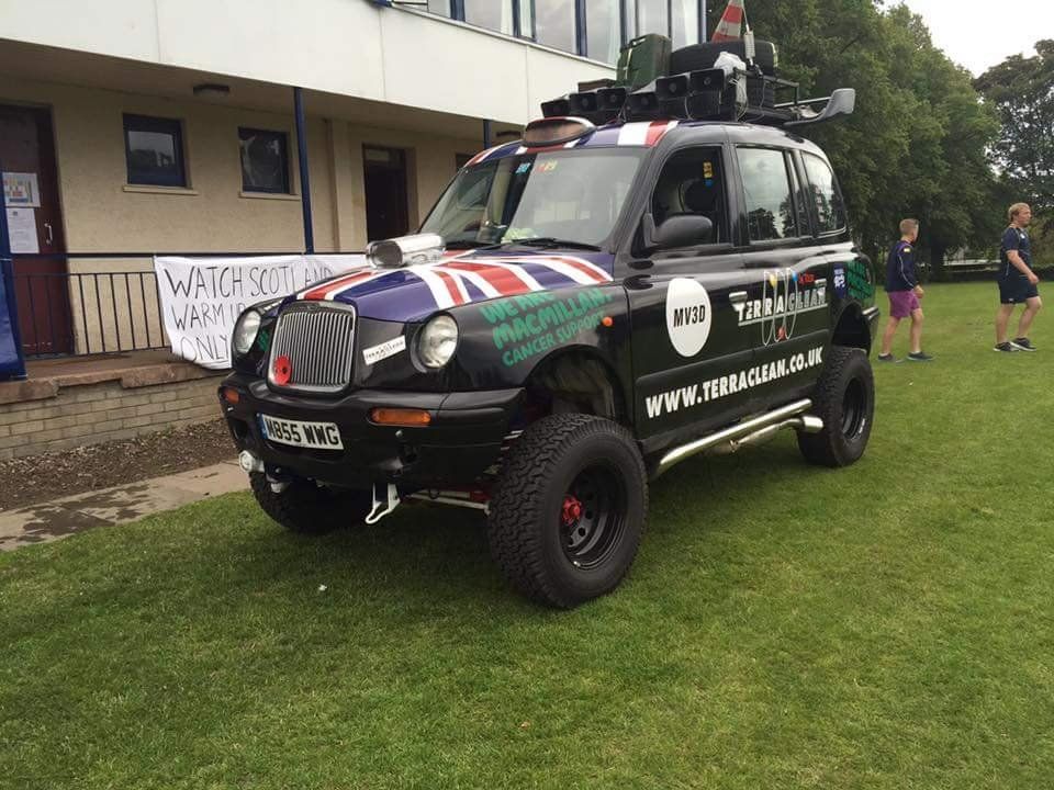 Black taxi with adverts printed on it