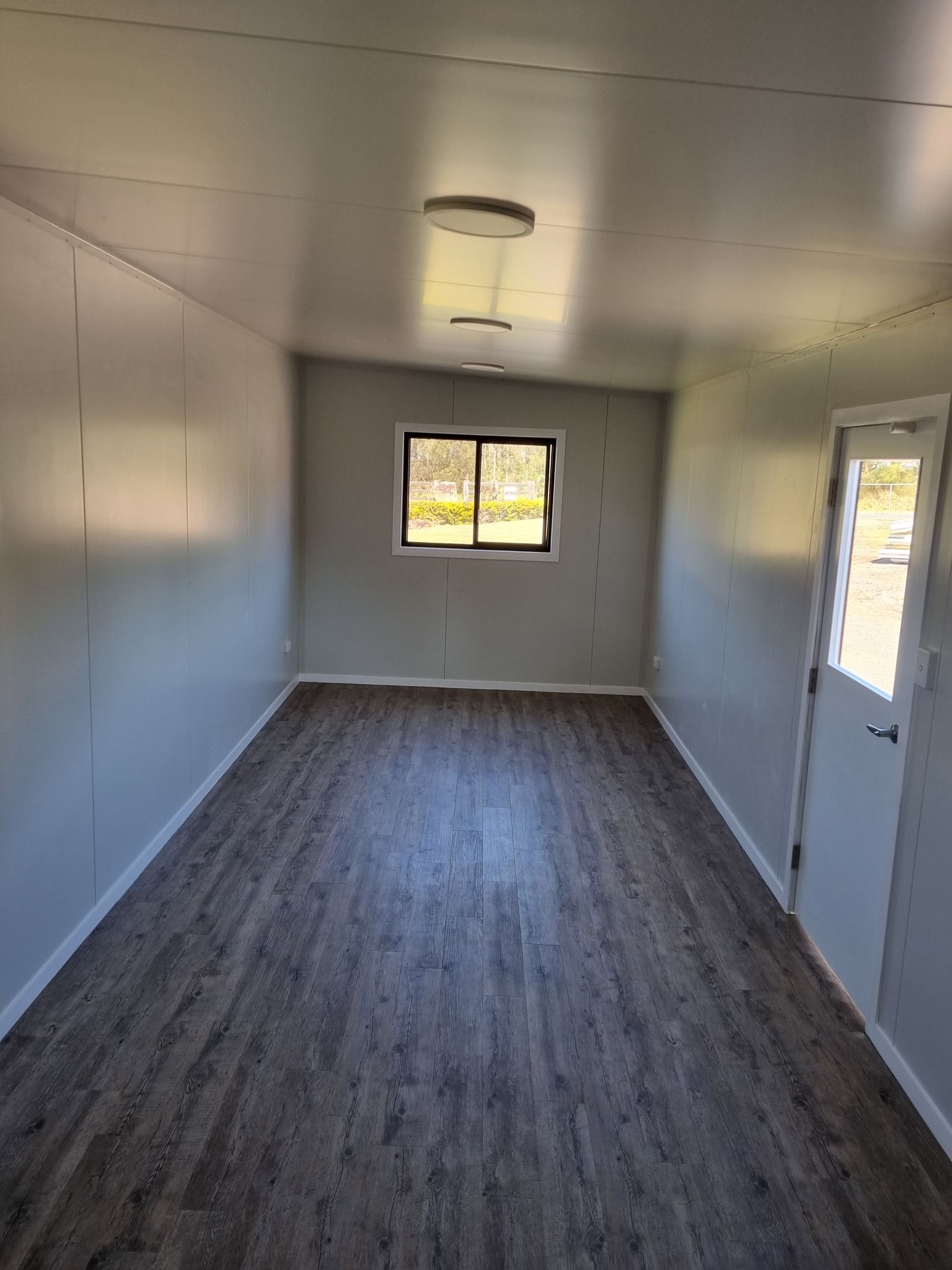 Room With Grey Walls, Wood-look Flooring, and Ceiling Lights — Taylormade Constructions & Renovations In Kingaroy, QLD