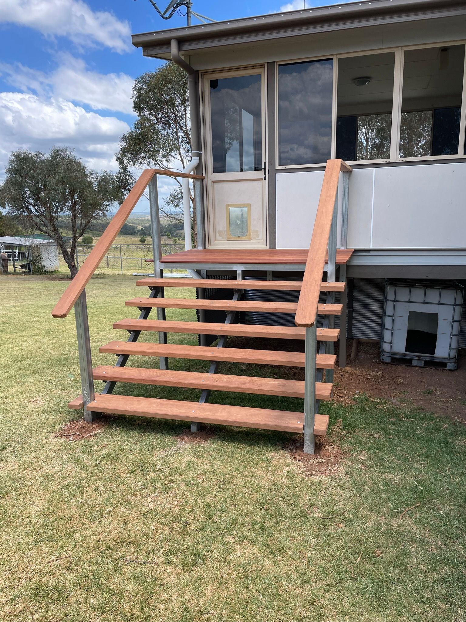 Wooden Steps With Metal Rails Leading Up to a House With Windows — Taylormade Constructions & Renovations In Kingaroy, QLD