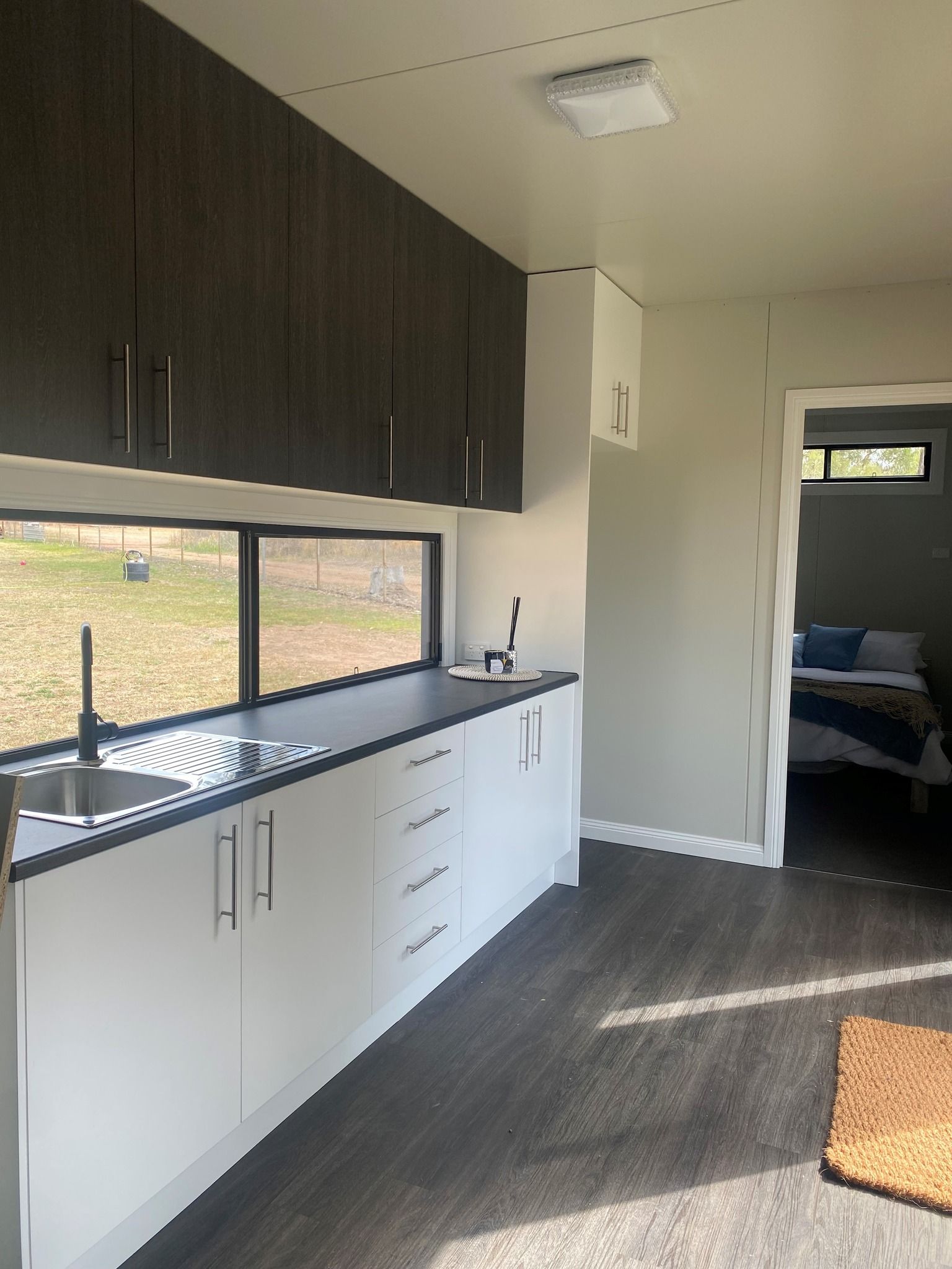 Modern Kitchen With Cabinets and a View Through the Window — Taylormade Constructions & Renovations In Kingaroy, QLD