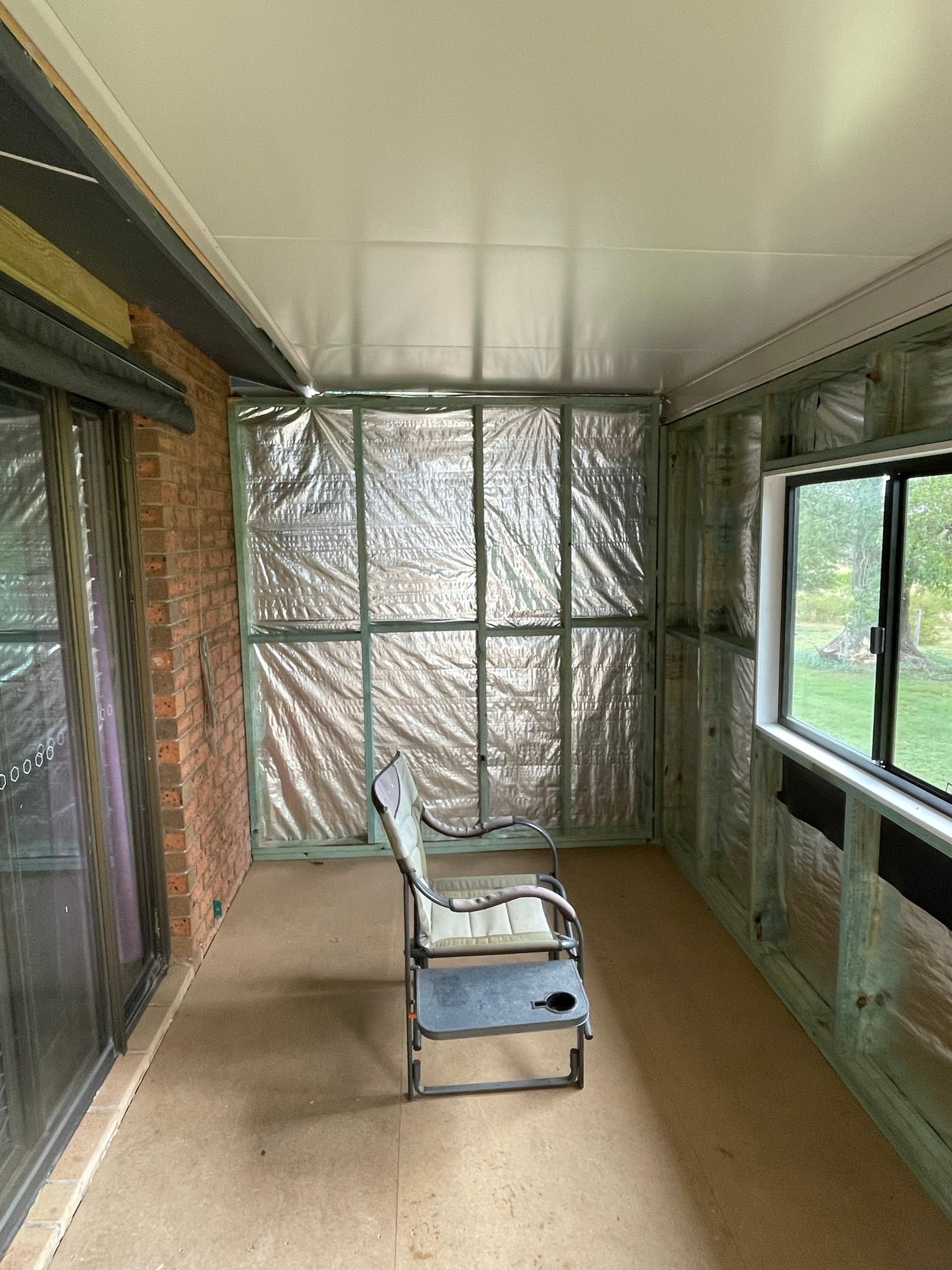 Unfinished Room With Insulation, Framing, and a Chair — Taylormade Constructions & Renovations In Goodger, QLD