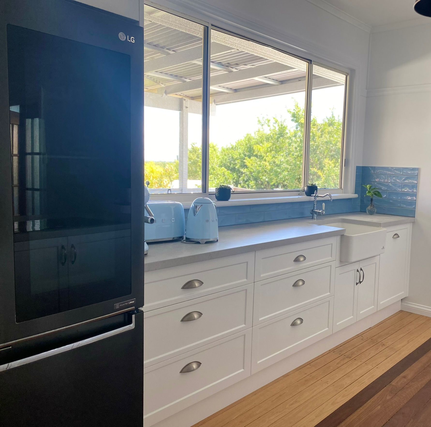 Kitchen With White Cabinets and a Black Refrigerator — Taylormade Constructions & Renovations In Nanango, QLD