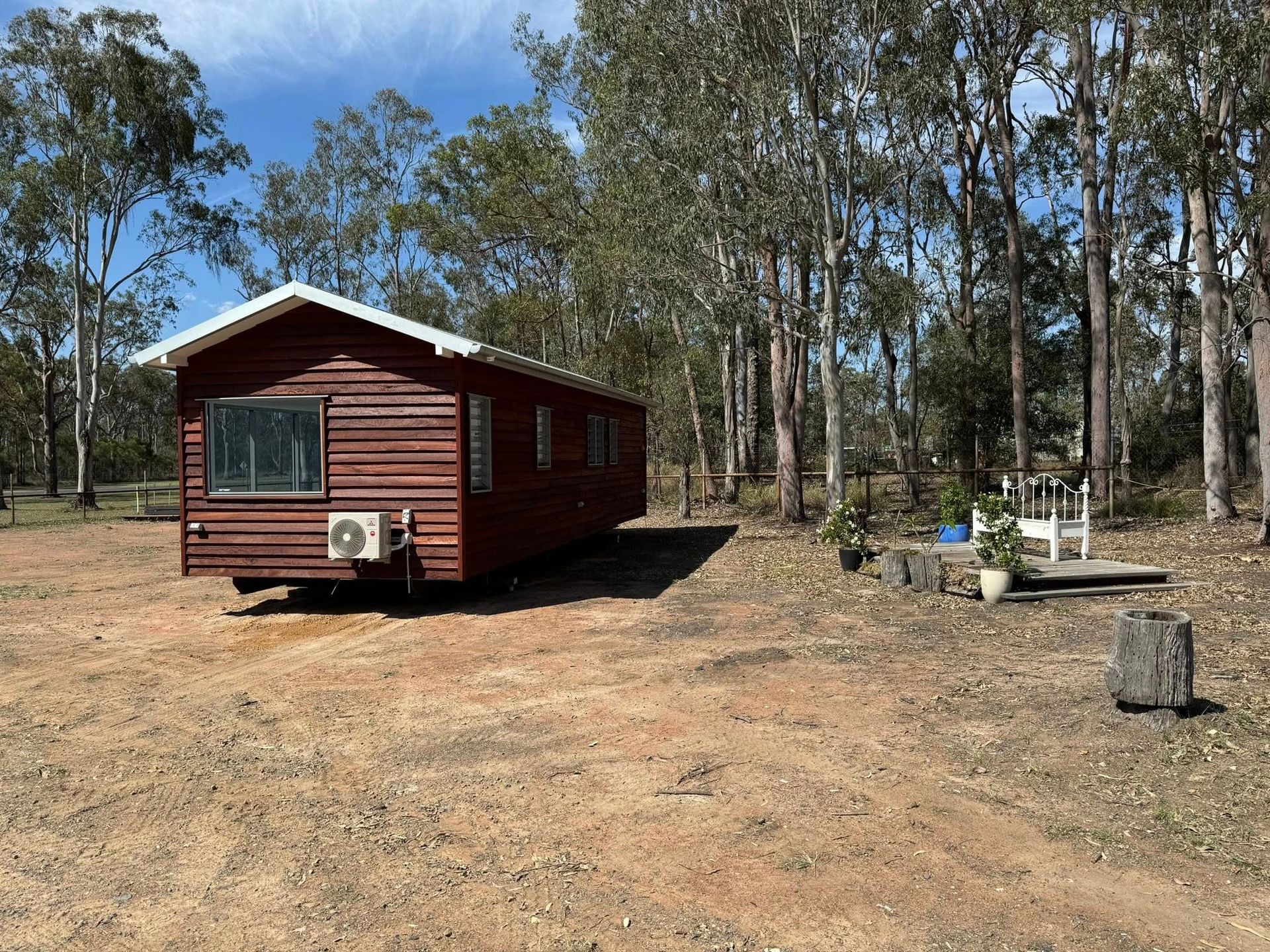 Brown Cabin on Wheels in a Dirt Lot, Surrounded by Trees — Taylormade Constructions & Renovations In Memerambi, QLD