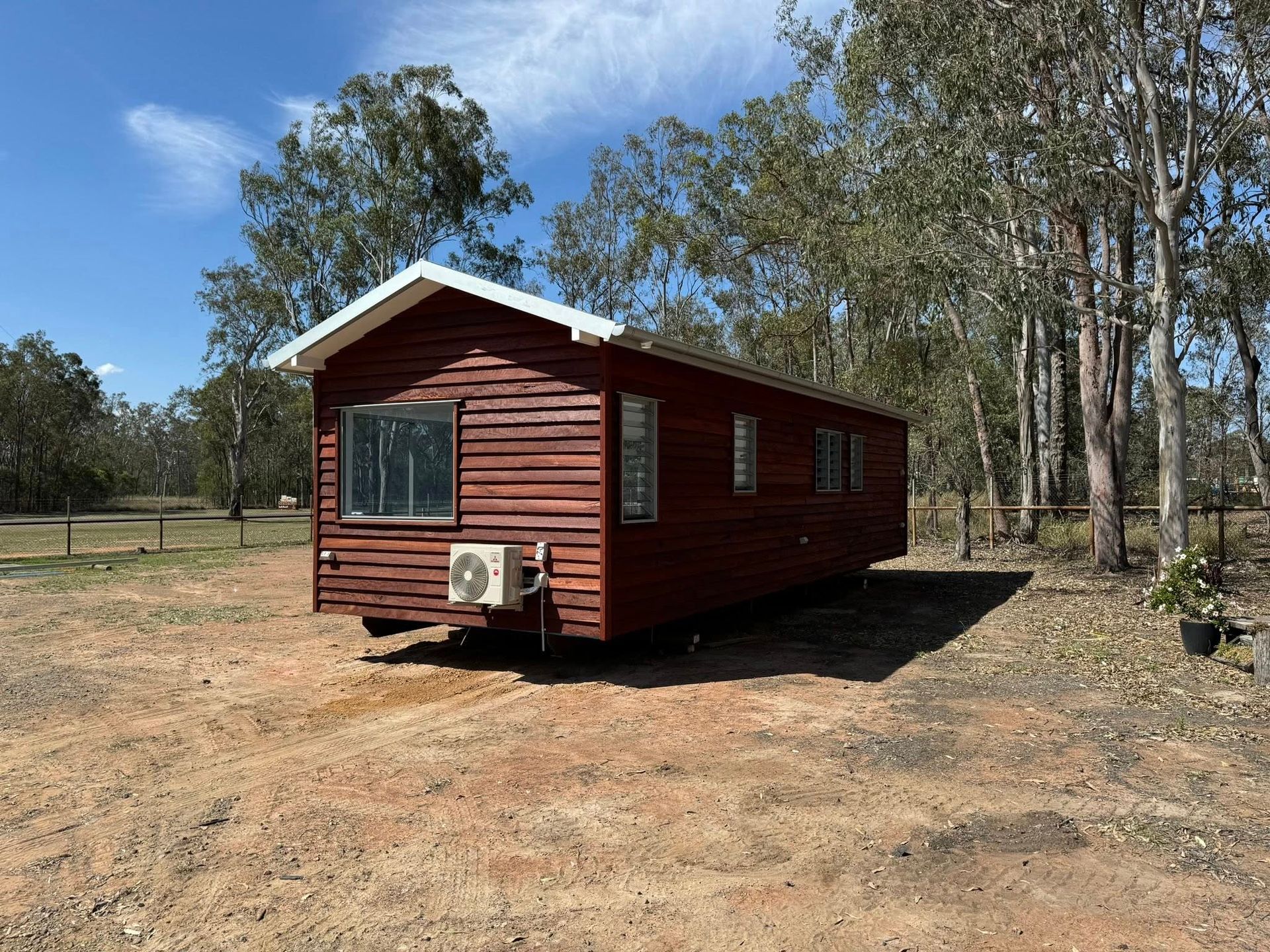 Wooden Cabin on a Trailer in a Sunny Field — Taylormade Constructions & Renovations In Kingaroy, QLD