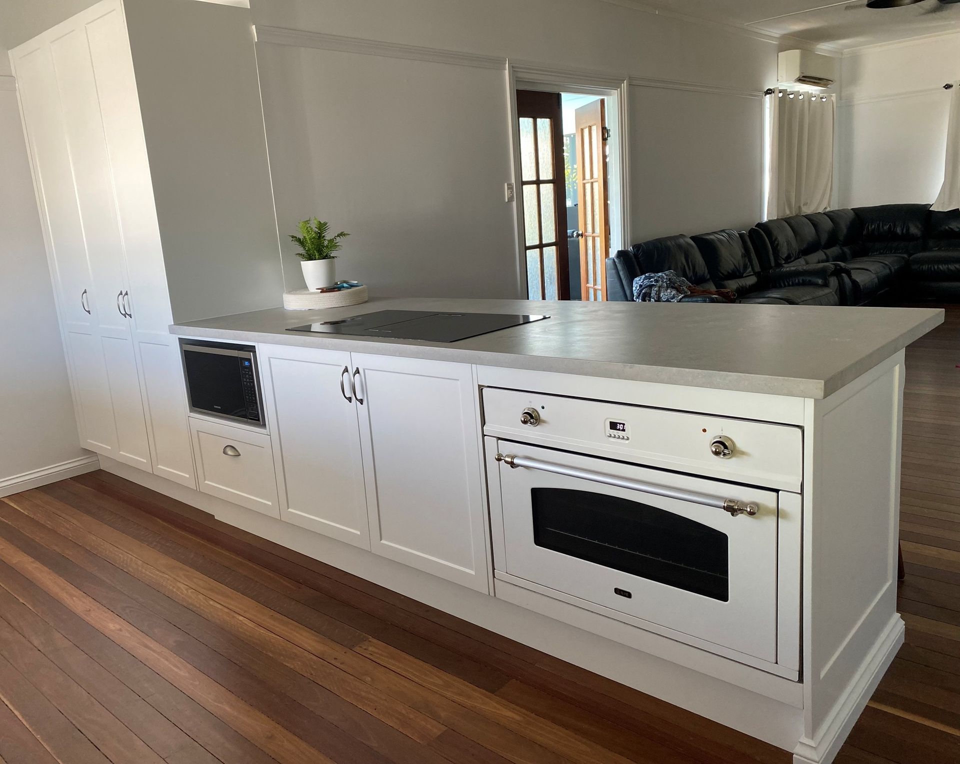 White Kitchen Island With a Built-in Oven, Stovetop, and Microwave — Taylormade Constructions & Renovations In Yarraman, QLD