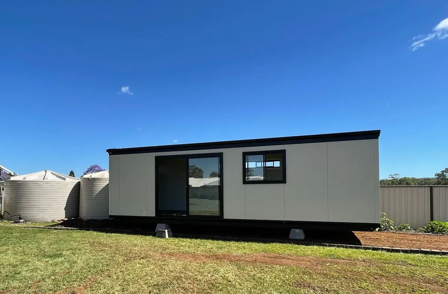 Small Rectangular Building With Black Trim and Sliding Glass Door — Taylormade Constructions & Renovations In Wooroolin, QLD