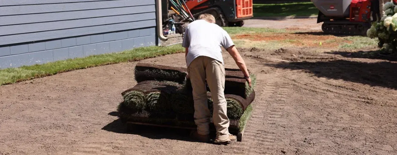 Trusted landscaping team improving front yard curb appeal with fresh mulch, shrubs, and lawn care in Chisago, MN
