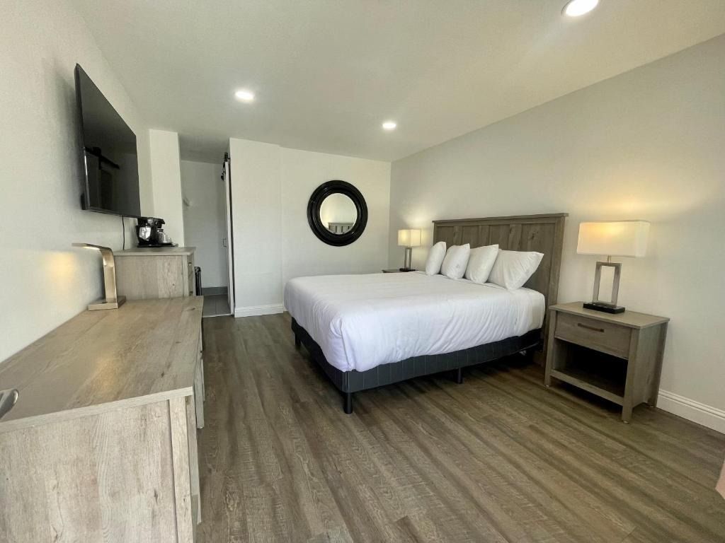 A hotel room with a king size bed and a flat screen tv.