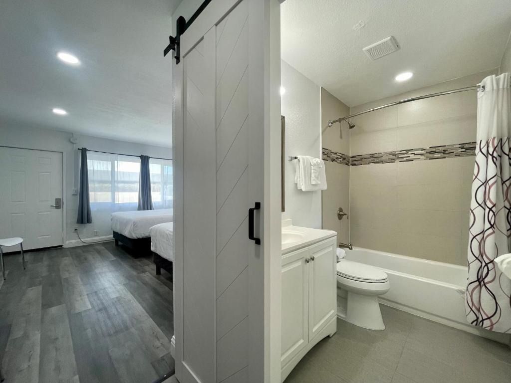 A bathroom with a toilet , sink , tub and shower.