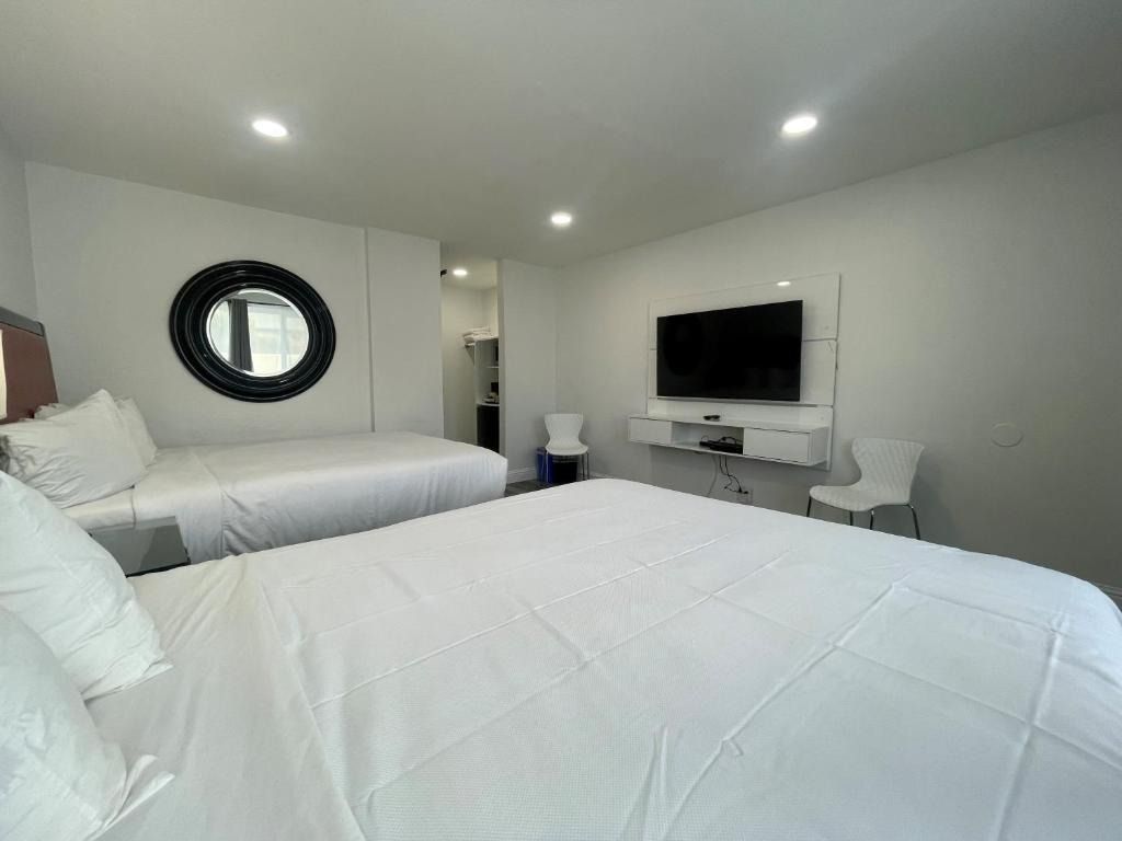 A hotel room with two beds and a flat screen tv.