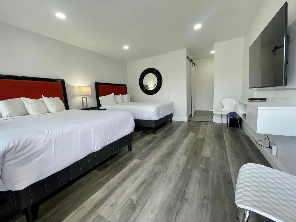 A hotel room with two beds and a flat screen tv.