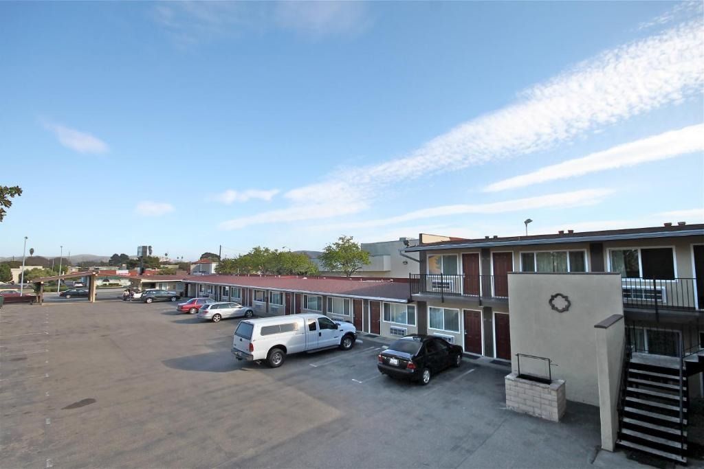 A lot of cars are parked in front of a motel