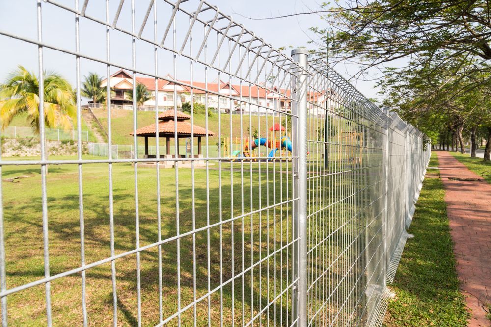 A Metal Fence Surrounds A Park With A Playground In The Background — Australian Advanced Fencing In Wauchope, NSW