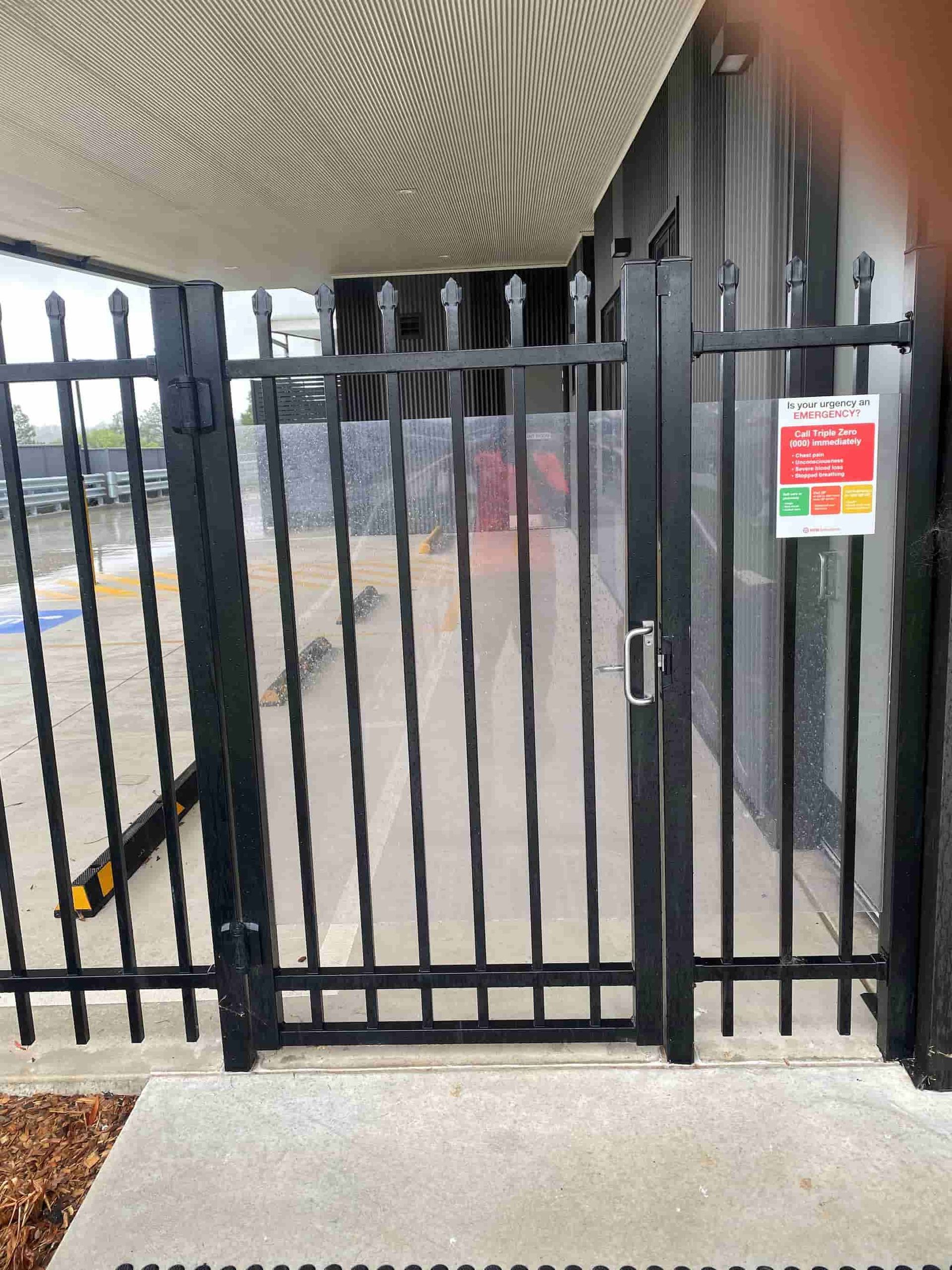 A Wooden Fence With A Gate In Front Of A House — Australian Advanced Fencing In Port Macquarie, NSW