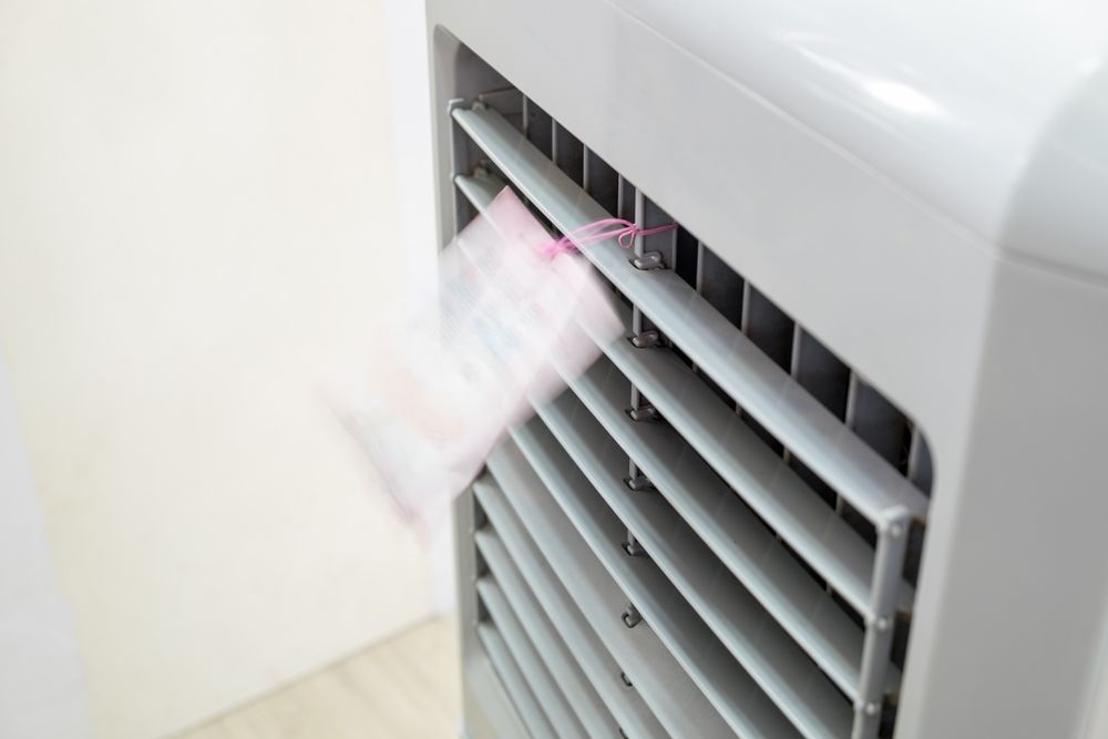 A Close Up of a Fan With a Piece of Paper Coming Out of It — FVS Airconditioning & Electrical Pty Ltd in Cloncurry, QLD