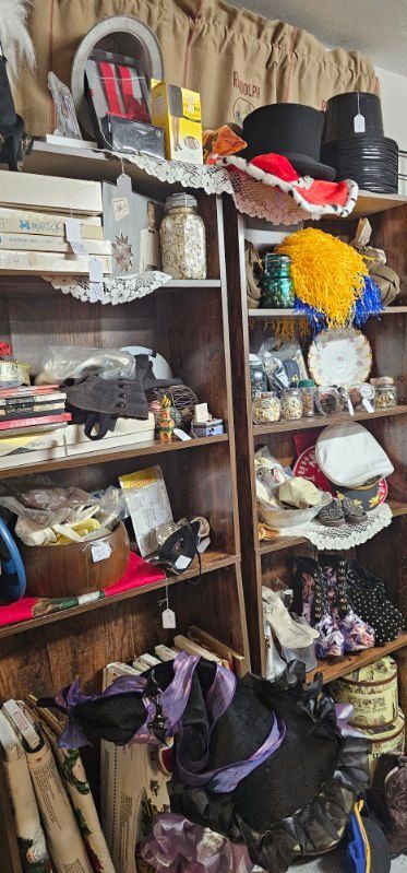 Shelves of assorted hats, scarves, bags, and handmade crafts in a cozy shop display