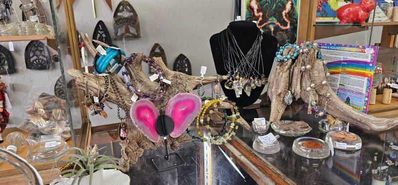 Decorative table display with ornate sandals, jewelry, and colorful accessories in a shop