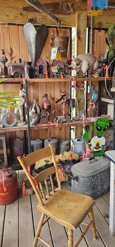 Rustic shop interior with shelves of bottles, decor, and a worn wooden chair in front