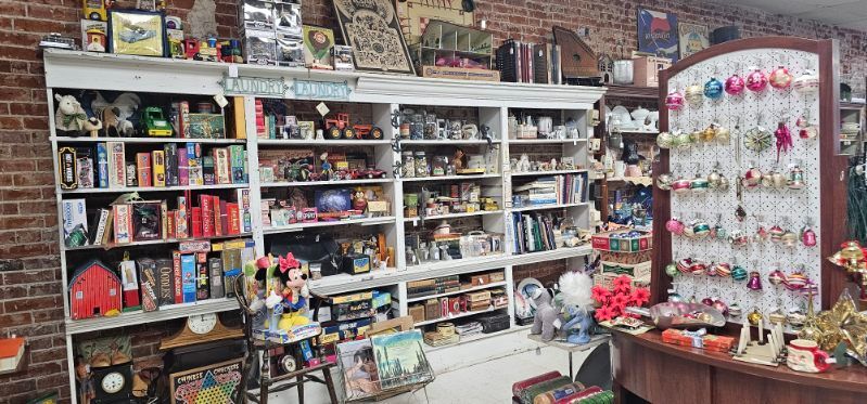 Toy and gift shop shelves filled with colorful toys, games, and small souvenirs in a brick-walled store