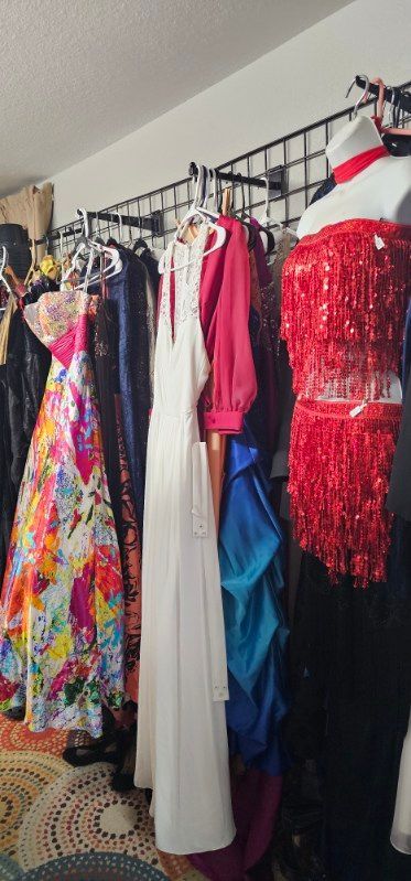 Rack of colorful dresses and gowns hanging in a clothing store