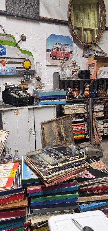 A vintage shop assistant sourcing antique decor from shelves and displays in a warmly lit store.