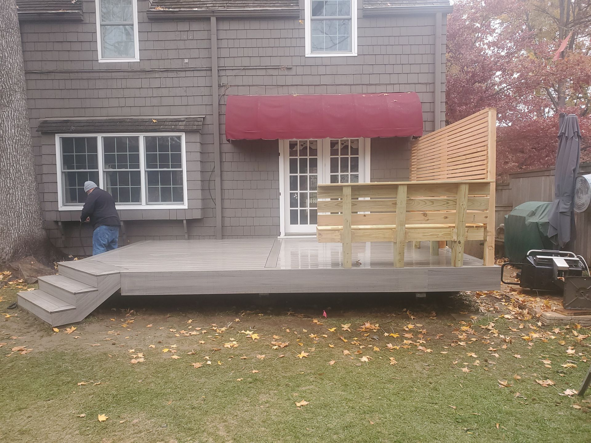 A man is working on a deck in front of a house.