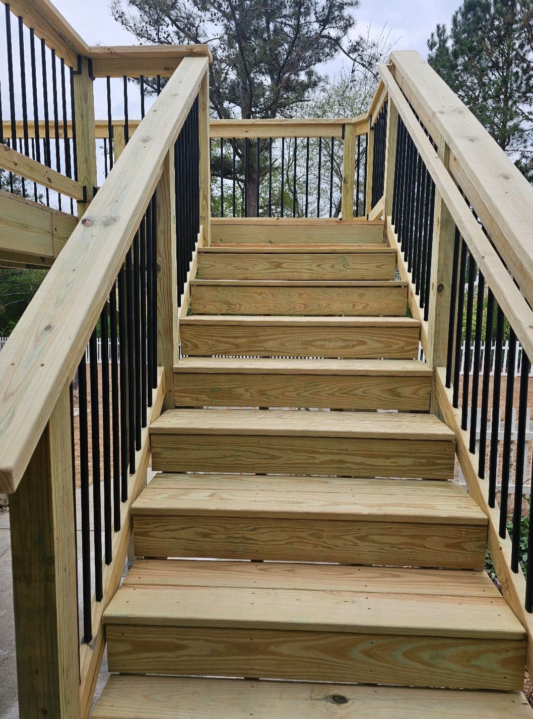 A set of wooden stairs with a metal railing