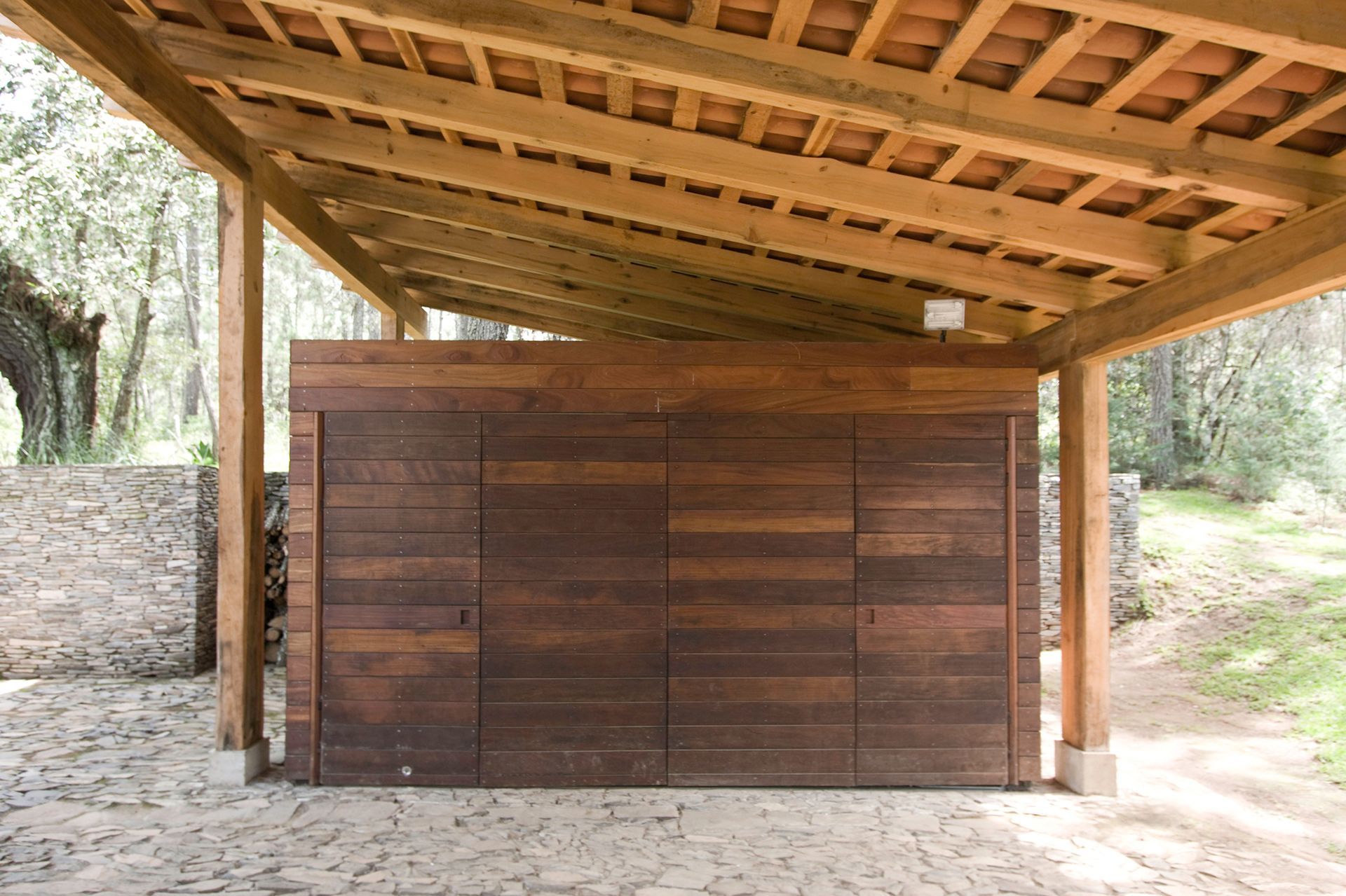A wooden garage door under a wooden roof