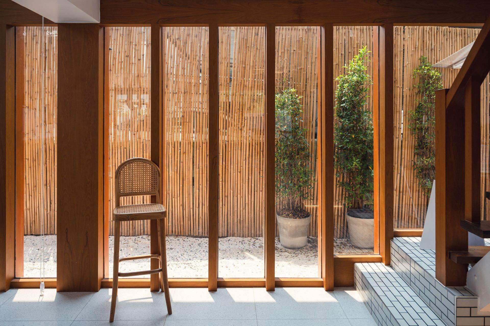 A chair is sitting in front of a large window in a room.