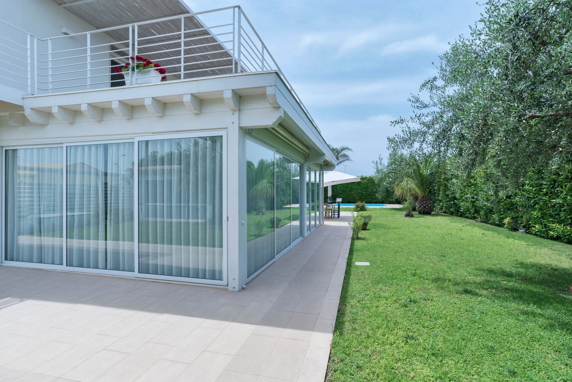A large white house with a balcony and sliding glass doors
