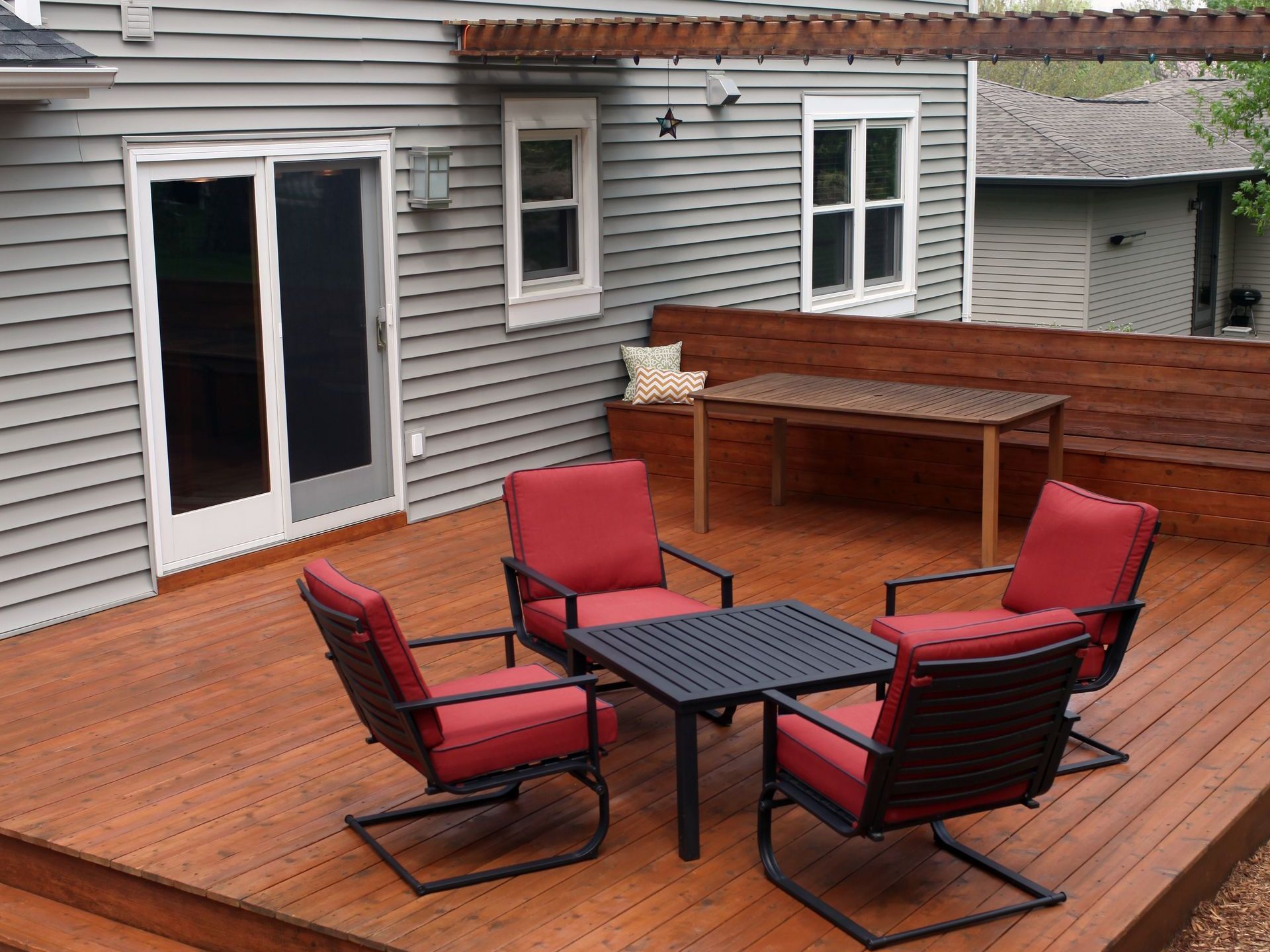 A wooden deck with chairs and a table in front of a house