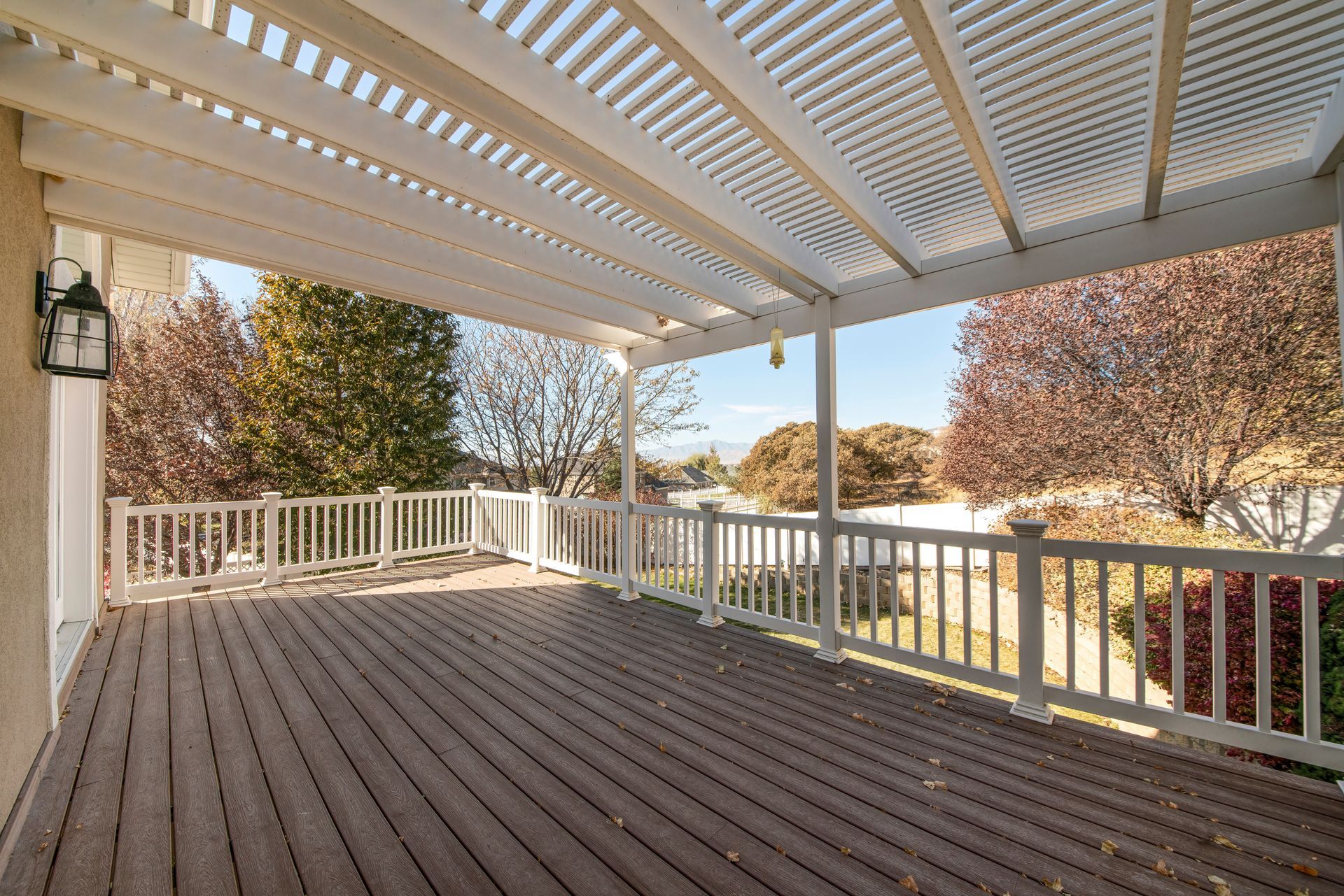 An empty deck with a white railing and a white roof.