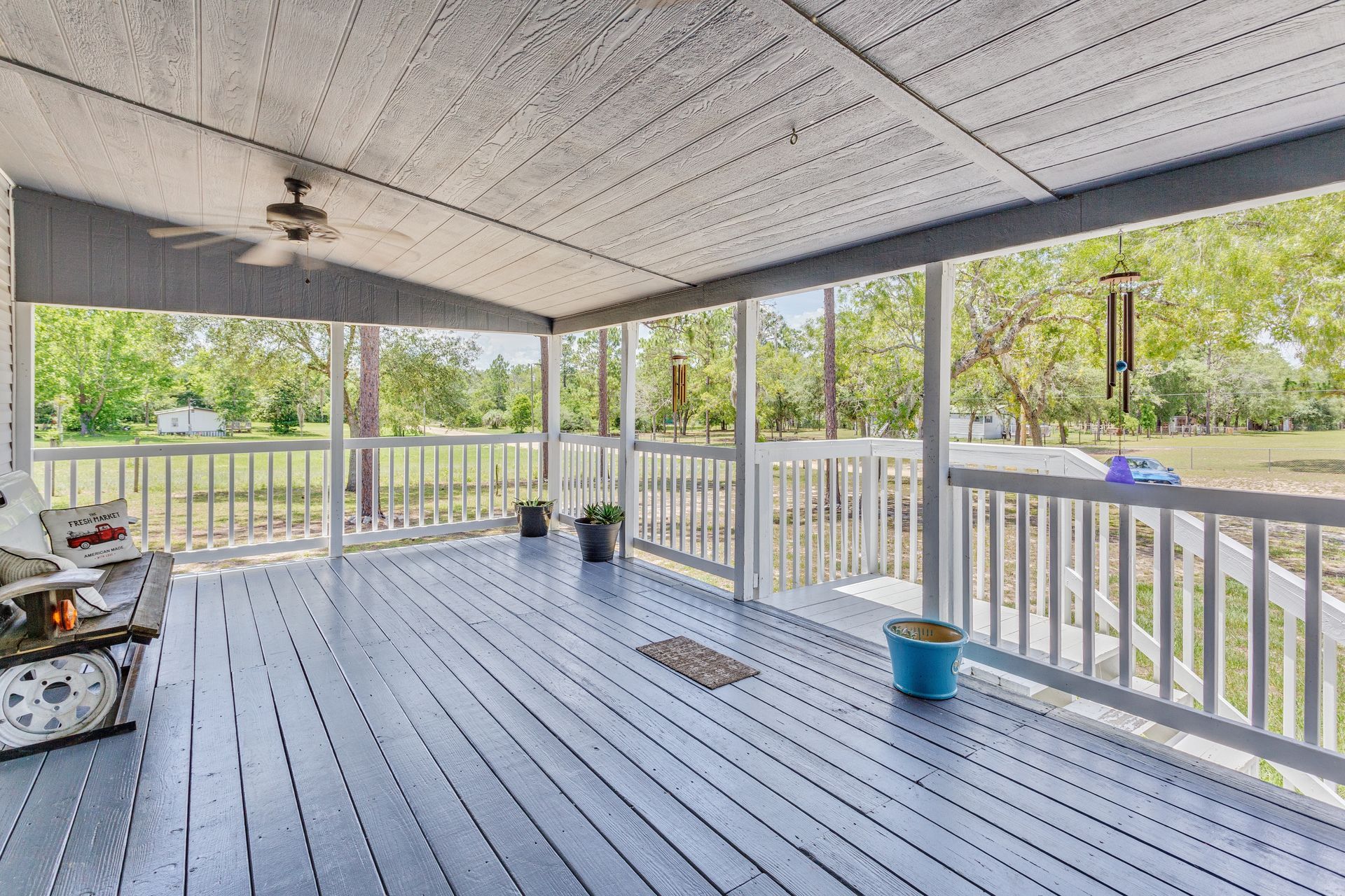A wooden deck with a metal railing is being built in front of a house.