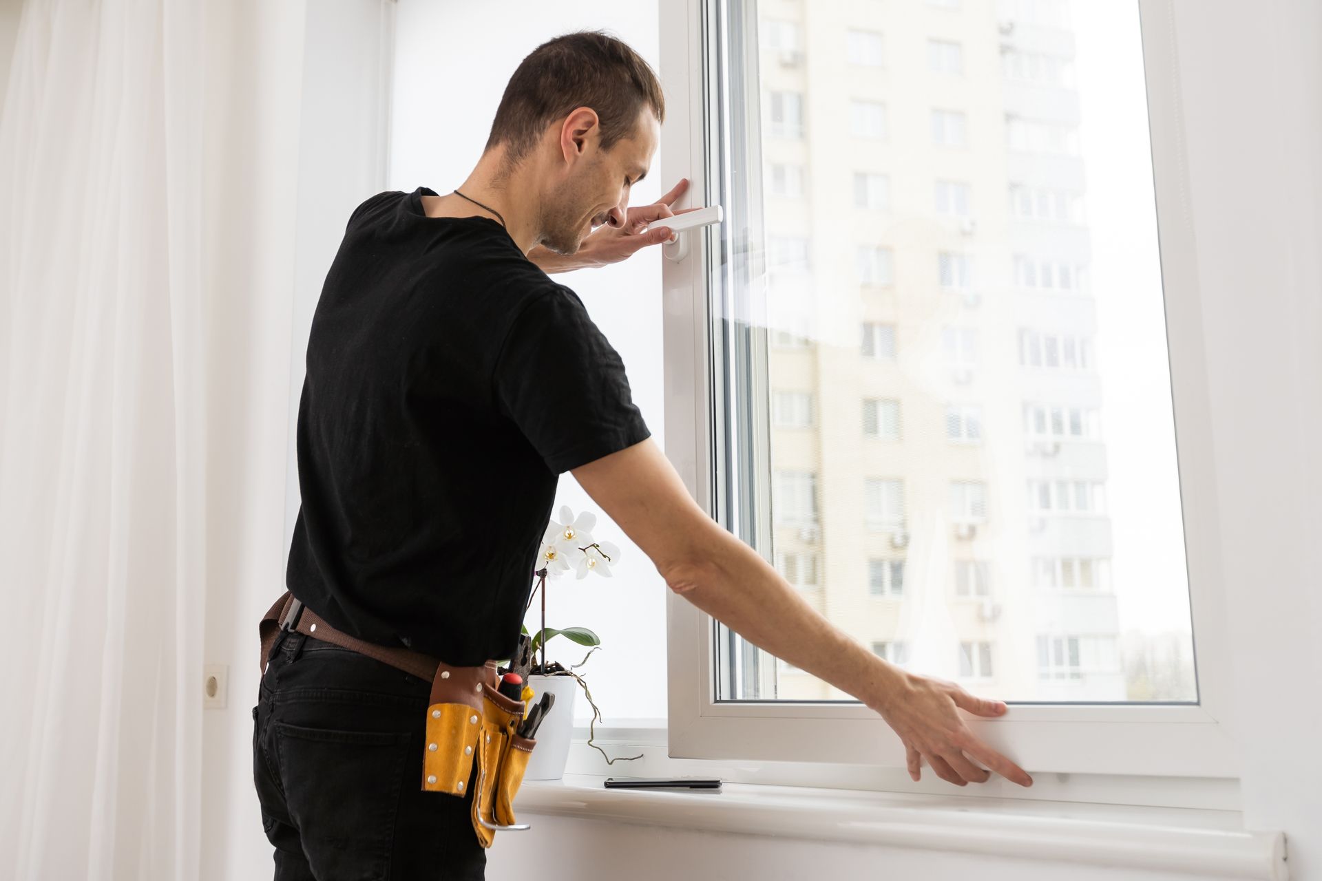 A man is installing a window in a room.
