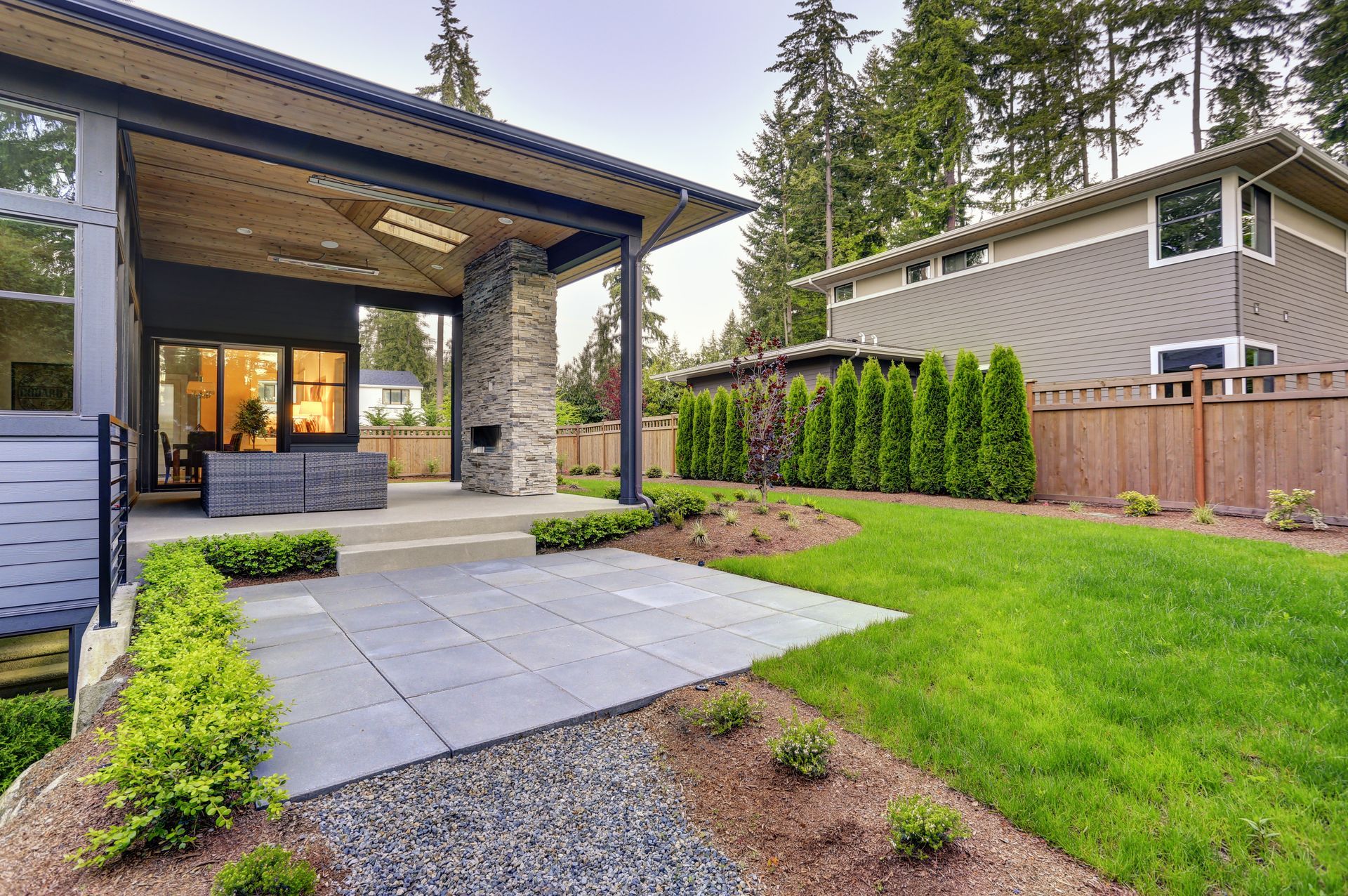 A house with a large lawn and a patio in front of it.