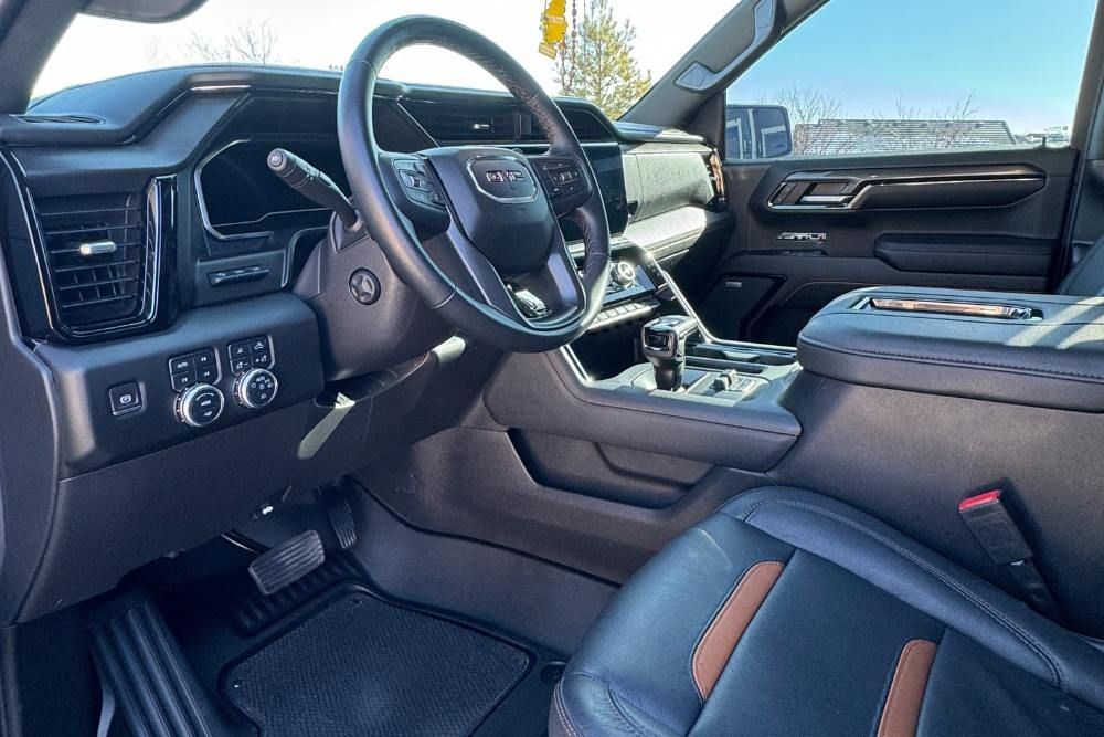 The interior of a car with a steering wheel and a dashboard.