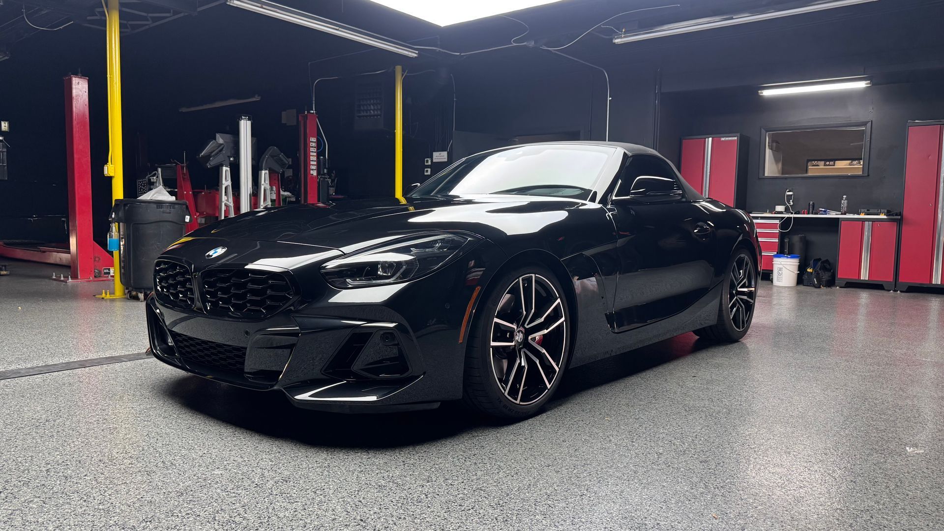 Black sports car in a garage, shot from the front-left side