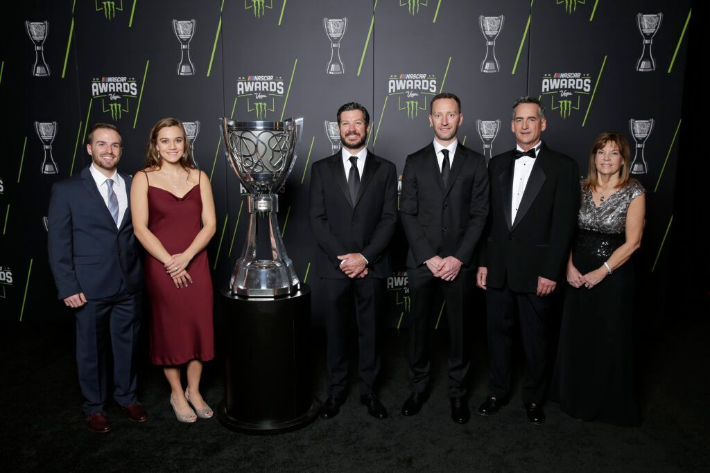 A group of people standing in front of a trophy